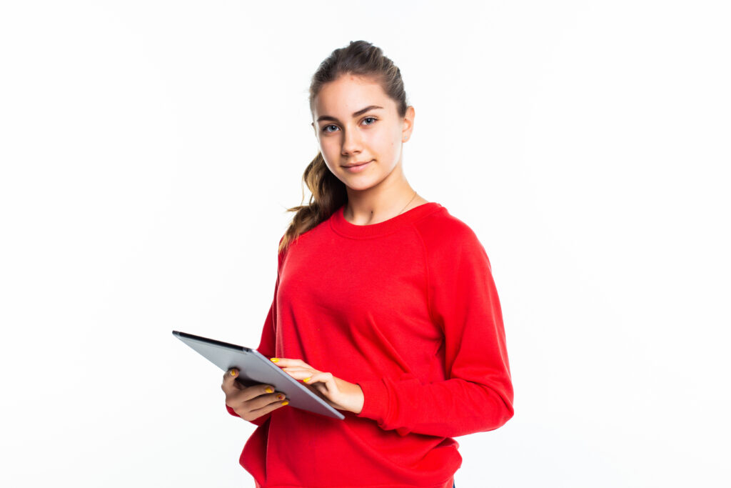 Happy beauty teen girl texting on a tablet on a white background